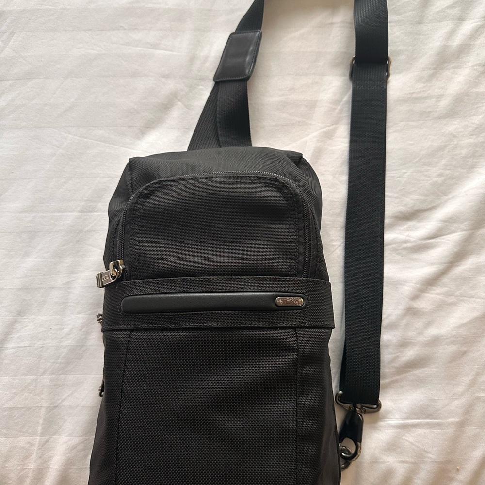Tumi Black Sling Bag with Adjustable Strap and Minimalist Design
